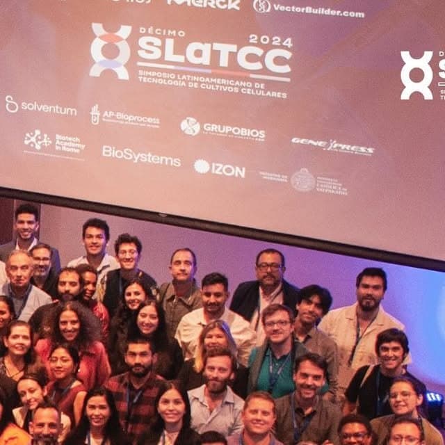 Fotografía de grupo de quienes asistieron al X SLATCC en Chile, frente a la pantalla con el logotipo de la décima edición y los de sus patrocinadores.